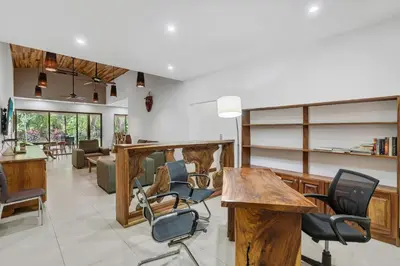 a living room with wooden tables and chairs at Spacious 3-Bedroom Coastal Home with Shared Pool, Outdoor Living & Steps to Playa Potrero in Potrero