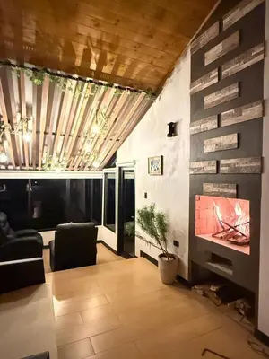 a living room with a couch and a fireplace at Cabañas de Montaña Magia del Poás in Poás