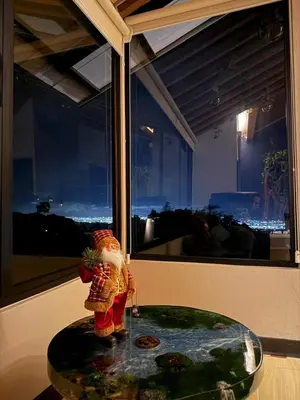 a figurine on a glass table in front of a window at Cabañas de Montaña Magia del Poás in Poás
