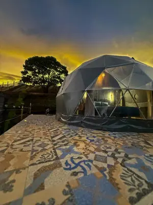 a tent on a tiled floor with a sunset in the background at Cabañas de Montaña Magia del Poás in Poás