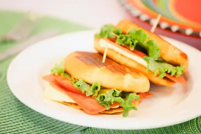 three sandwiches on a white plate on a table at Hotel La Hacienda in Quesada
