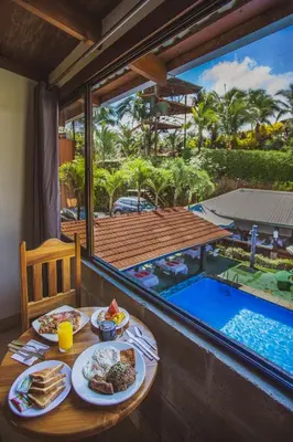 a table with plates of food and a swimming pool at Hotel La Hacienda in Quesada