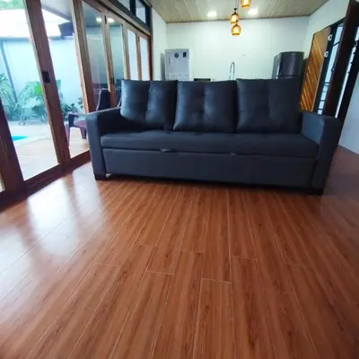 a couch in a living room with a wooden floor at Casa Luna in Tanque
