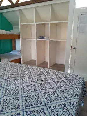 a bedroom with a bed and a book shelf at Gaudy's Hostel in San José