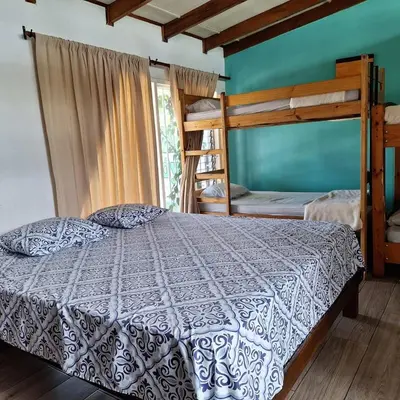 a bedroom with a bed and two bunk beds at Gaudy's Hostel in San José