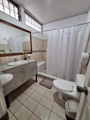 a bathroom with a sink and a toilet and a tub at Gaudy's Hostel in San José