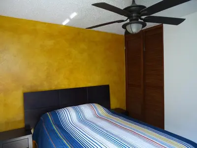 a bedroom with a bed and a ceiling fan at Jaco Costa Linda Condo in Jacó