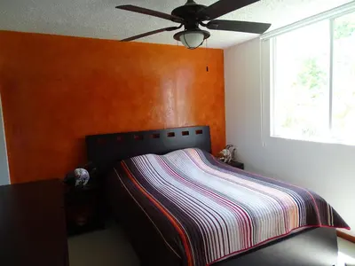 a bedroom with a bed and a ceiling fan at Jaco Costa Linda Condo in Jacó