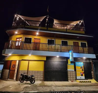 a motorcycle parked in front of a building at night at Lilo apartamento, bello y lujoso in Liberia