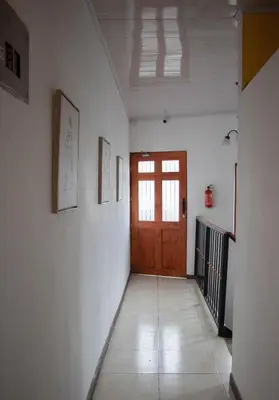 a hallway with a wooden door and a tile floor at Lilo apartamento, bello y lujoso in Liberia