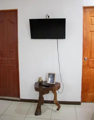 a room with a table with a television on a wall at Lilo apartamento, bello y lujoso in Liberia
