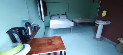 a room with a bed and a table and a sink at Árbol de mayo in Guápiles