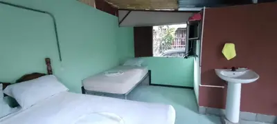 a small room with a bed and a sink at Árbol de mayo in Guápiles
