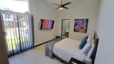 a bedroom with a bed and a painting on the wall at Pop House with private pool at Ciudad del Mar in Jaco in Jacó