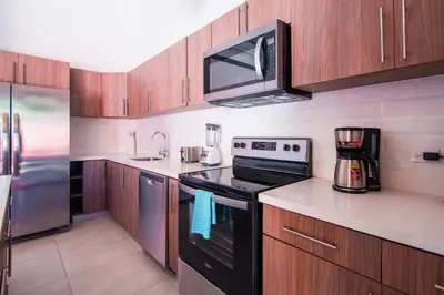 a kitchen with a black stove and a microwave at Pop House with private pool at Ciudad del Mar in Jaco in Jacó