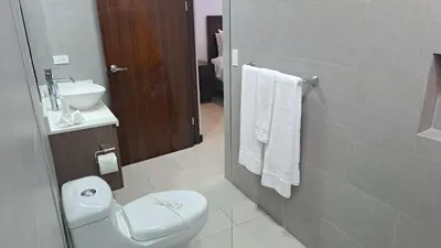 a bathroom with a white toilet and a sink at Pop House with private pool at Ciudad del Mar in Jaco in Jacó