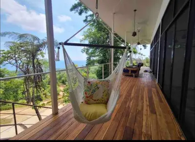 a hammock on the porch of a house at Jungle paradise in Ballena