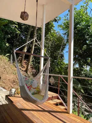 a hammock on the deck of a house at Jungle paradise in Ballena