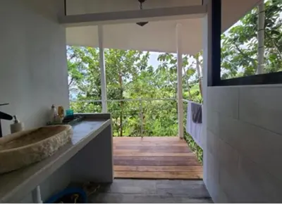 a bathroom with a tub and a view of the forest at Jungle paradise in Ballena