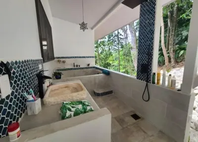 a bathroom with a large tub and a window at Jungle paradise in Ballena