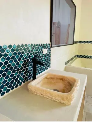 a sink in a bathroom with blue tiles at Jungle paradise in Ballena