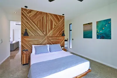 a bedroom with a large bed with a wooden headboard at Villa Alba 4ensuite rooms ocean view Malpais in Mal País