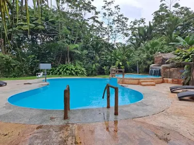 a pool at a resort with a water slide at Hotel Catarata Río Celeste in Bijagua