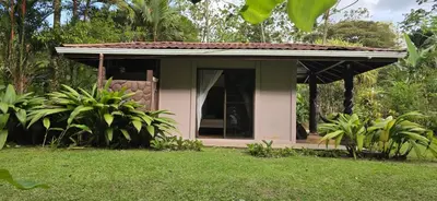 a small house with a window in a yard at Hotel Catarata Río Celeste in Bijagua
