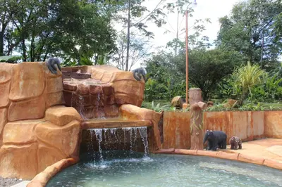 a water fountain in a park with two elephants in it at Hotel Catarata Río Celeste in Bijagua