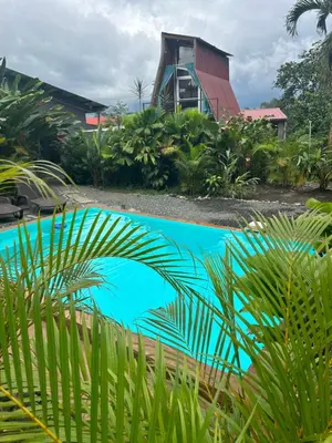 a swimming pool in front of a house with a building at IkI Tiny Villa in Fortuna