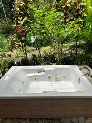 a white bath tub sitting in front of some plants at IkI Tiny Villa in Fortuna