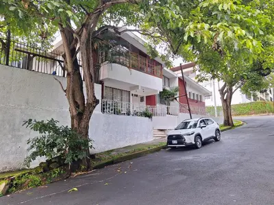 a small car parked in front of a house at Carolina Hostel in San José