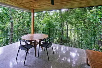 a wooden table and chairs on a balcony with trees at Casas Alba - 1 bedroom Loft private kitchen bathroom and terrace Malpais in Mal País