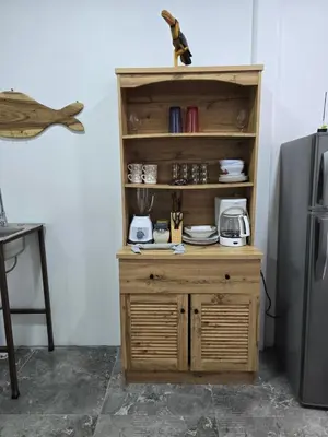 a wooden cabinet in a kitchen next to a refrigerator at Monkey House in Tortuguero