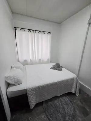 a small bedroom with a bed and a window at Monkey House in Tortuguero