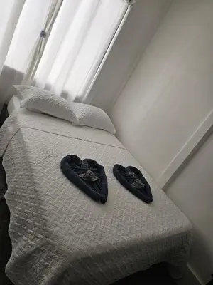 two pairs of slippers sitting on top of a bed at Monkey House in Tortuguero