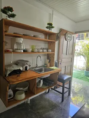 a kitchen with a sink and a table and a chair at Monkey House in Tortuguero