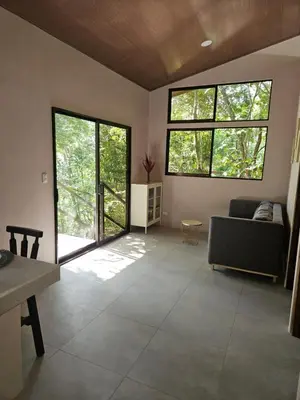 a living room with large windows and a couch at Villas Gecko in San Juanillo