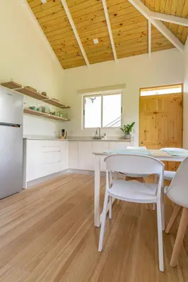 a kitchen with a white table and a white refrigerator at Cedrela Beach Villas in Uvita