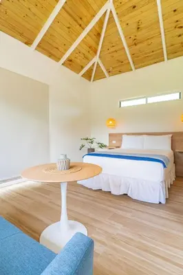 a bedroom with a bed and a table at Cedrela Beach Villas in Uvita