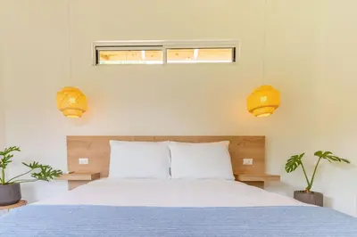 a bedroom with a bed and two potted plants at Cedrela Beach Villas in Uvita