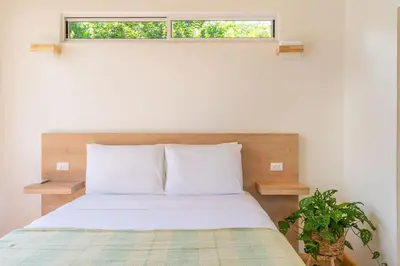 a bedroom with a bed with a window above it at Cedrela Beach Villas in Uvita