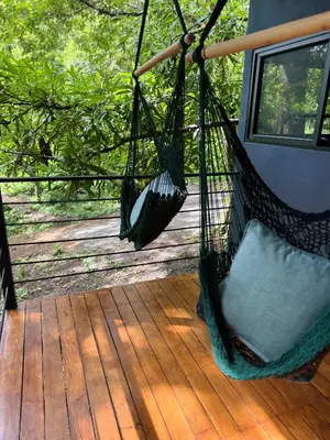 a porch with two hammocks on a deck at Deer Houses Cabuya in Cabuya