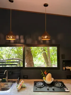 a kitchen with a counter with a sink and two windows at Deer Houses Cabuya in Cabuya
