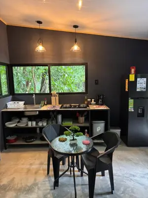 a kitchen with a table and chairs and a counter at Deer Houses Cabuya in Cabuya