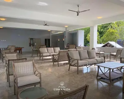 a living room with chairs and tables and a room with a fire place at Punta Esmeralda, Puntarenas Great Apartment in Quebrada Ganado