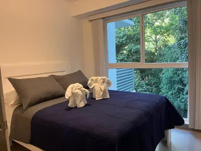 two stuffed elephants sitting on a bed with a window at Punta Esmeralda, Puntarenas Great Apartment in Quebrada Ganado