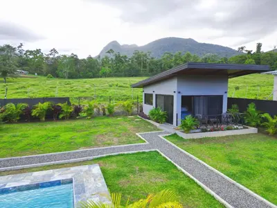 a house with a garden and a swimming pool at Casitas del Arenal in Fortuna