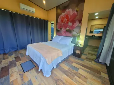 a bedroom with a bed with a painting on the wall at Casitas del Arenal in Fortuna