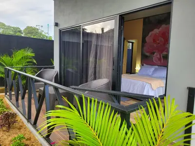 a balcony with a bed and a bedroom on it at Casitas del Arenal in Fortuna